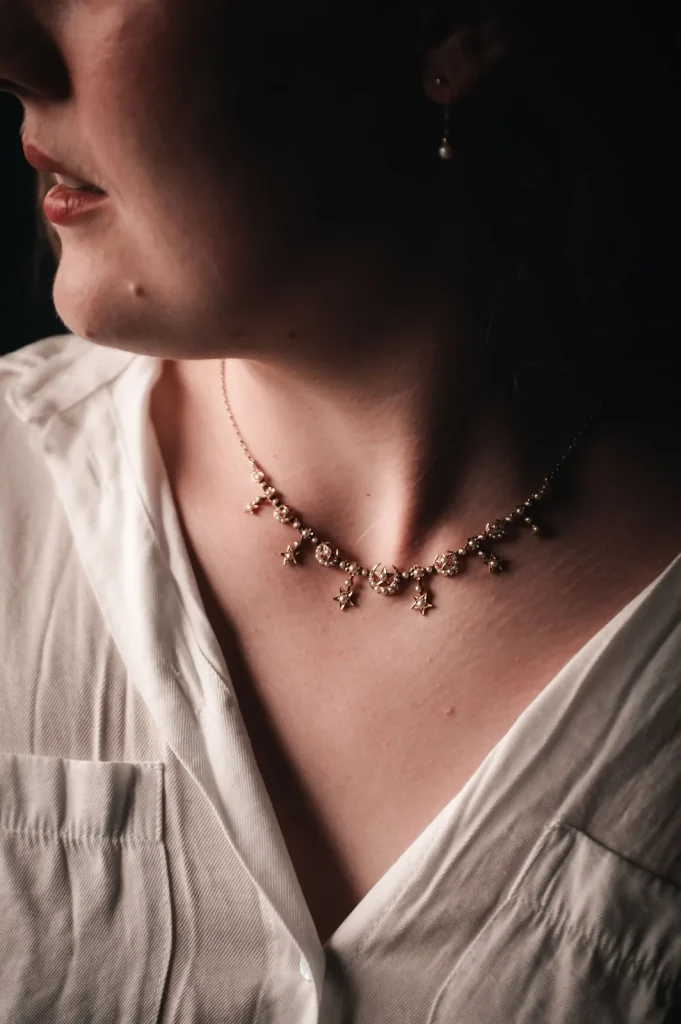 Close-up of a delicate gold star necklace on a bride's collarbone