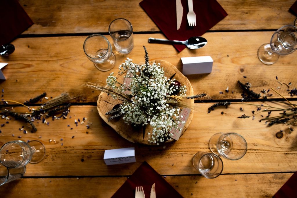 Overhead view of a wooden reception table set with glasses, name cards and gypsophila